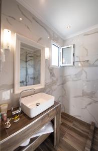 a bathroom with a white sink and a mirror at Villa Verde in Lefkada