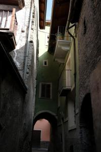 an alley with a green building and an archway at Bed & Breakfast Gabriella EXILLES in Exilles