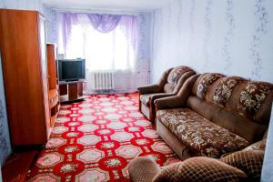 a living room with a couch and a television at Апартаменты Ленина, 30 in Lapshinskiy