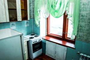 a small kitchen with a stove and a window at Апартаменты Ленина, 30 in Lapshinskiy