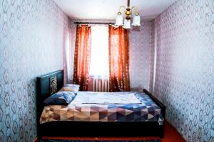 a bedroom with a bed and a window at Апартаменты Ленина, 30 in Lapshinskiy