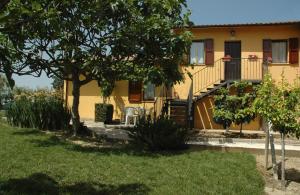 デルータにあるCasale il Colle Derutaの木と庭のある黄色い家