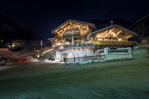 a large wooden building with a fence in front of it at Apartments Anemone in Samnaun