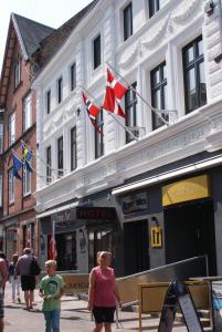 a woman and a child walking in front of a building at Hotel Jomfru Ane in Aalborg