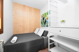 1 dormitorio con 1 cama y pared de madera en EnjoyGranada CARLOS CANO I, en Granada