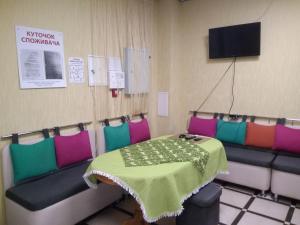 Zimmer mit einem Tisch und Stühlen sowie einem TV in der Unterkunft Parasolka in Luzk