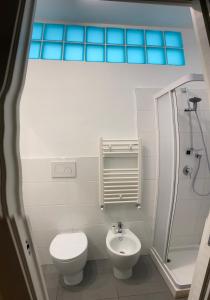 een witte badkamer met een toilet en een wastafel bij Casa Papapietro in Matera