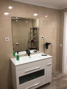 een badkamer met een witte wastafel en een spiegel bij Loft romántico in Algeciras