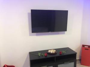 a flat screen tv hanging on a white wall at Loft romántico in Algeciras