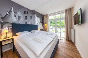 een slaapkamer met een groot bed en een groot raam bij Lake House Plön in Plön