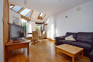 a living room with a couch and a tv at The Loft, Angmering-On-Sea in East Preston