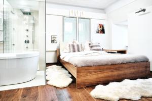 Schlafzimmer mit einem Bett, einer Badewanne und einem Waschbecken in der Unterkunft Kaiser Apartments - City Centre of Graz in Graz