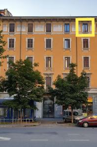 a large orange building with cars parked in front of it at Silenzioso nido su 2 piani nella Milano più bella in Milan