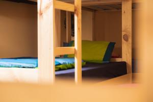 a bunk bed with blue and green pillows on it at Refugio de Bujaruelo in Torla-Ordesa