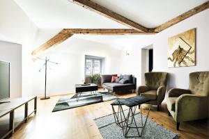 uma sala de estar com paredes brancas e vigas de madeira em Kaiser Apartments - City Centre of Graz em Graz