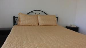 Una cama con dos almohadas encima. en Westcliff Hotel en Lira