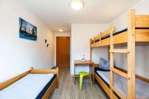 a bedroom with bunk beds and a desk at Jugendherberge Wunsiedel in Wunsiedel