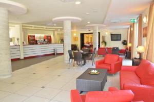 - un hall avec des meubles rouges et un coin d'attente dans l'établissement Hotel La Ninfea, à Montesilvano