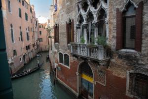 a canal between two buildings with a boat in the water at Appartamenti Venezia in Venice