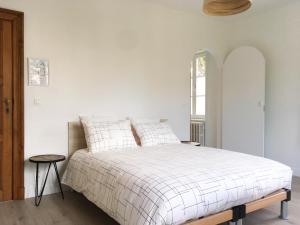 a white bedroom with a bed and a window at B&B Villa Bon Papa in De Panne