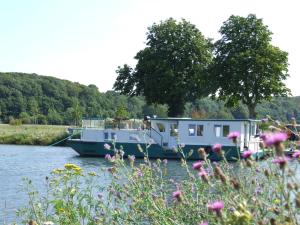 a house boat is docked on a river at Gîte Fluvial de La Baie de Somme Le Lihoury in Saint-Valery-sur-Somme