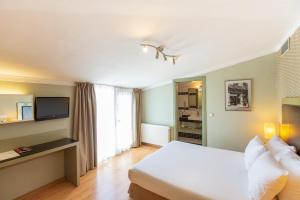 1 dormitorio con 1 cama blanca y TV en Hotellino Istanbul, en Estambul