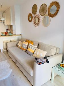 un divano in soggiorno con specchi sul muro di Apartamento Iris a Benalmádena