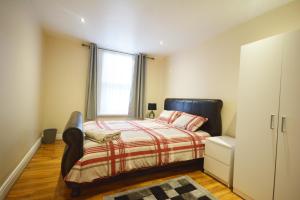 a bedroom with a bed and a window at London Zone 2 Three Bedroom Apartment in London
