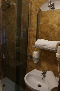 La salle de bains est pourvue d'un lavabo et d'une douche en verre. dans l'établissement Bukowa Przystań Barlinek, à Barlinek