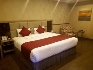 a hotel room with a large bed and a chair at Ramada by Wyndham Bishkek Centre in Bishkek