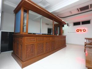a wooden reception desk in a room at Super OYO 89435 Nusantara Group Hotel in Jertih