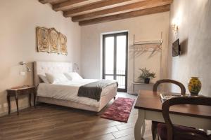 a bedroom with a bed and a table and a desk at Conte Federico Apartments in Palermo