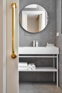 a bathroom with a mirror, sink, and bathtub at Cosmo Hotel Boutique in Valencia