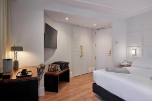 una camera con letto e scrivania e una camera di Cosmo Hotel Boutique a Valencia