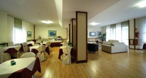 a restaurant with tables and chairs in a room at Hotel Cristallo Brescia in Brescia