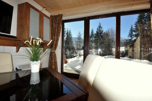 コシチェリスコにあるMSC Apartments Cicha Wodaのデスク、雪が降り注ぐ窓が備わる客室です。