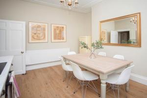 a dining room with a table and a mirror at City View - 11 Southcot Place in Bath