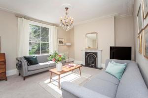 ein Wohnzimmer mit einem Sofa und einem Tisch in der Unterkunft City View - 11 Southcot Place in Bath