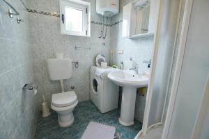 La salle de bains est pourvue de toilettes, d'un lavabo et d'un lave-linge. dans l'établissement Apartment Kliska, à Rovinj