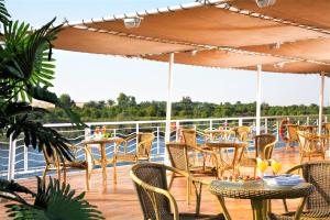 una terraza con mesas y sillas en un crucero en Jaz Crown Jubilee Nile Cruise - Every Thursday from Luxor for 07 & 04 Nights - Every MondayFrom Aswan for 03 Nights, en Luxor