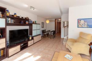 a living room with a television and a couch and a table at Villas del Montgo in Denia