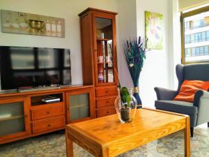 - un salon avec une télévision et une table basse dans l'établissement Balcón de la Bahía Gran Canaria, à Las Palmas de Gran Canaria