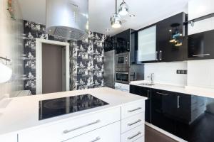 a kitchen with white cabinets and black and white wallpaper at Bilbao Volantin II with jacuzzi by Aston Rentals in Bilbao