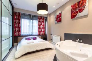 um quarto com uma cama, uma banheira e um lavatório em Bilbao Volantin II with jacuzzi by Aston Rentals em Bilbao