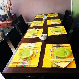 a long table with yellow napkins and forks and knives at Charming Rooms Opuntia in Carloforte