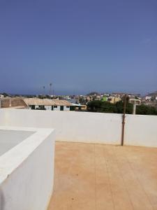 a white wall with a view of a city at Résidence Yô in Mindelo