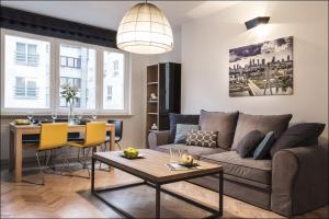 a living room with a couch and a table at P&O Serviced Apartments NOWOGRODZKA in Warsaw