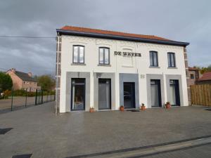 een wit gebouw met een bord aan de zijkant bij Luxurious Holiday Home in Glabbeek with Garden in Bunsbeek