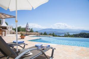 a villa with a swimming pool and a patio with chairs and an umbrella at Villa Venetia Corfu in Agnítsini