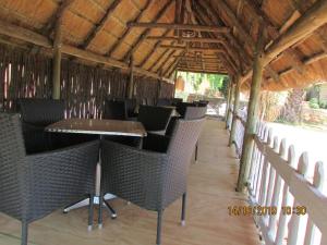Leribe的住宿－Aloes Lodge，餐厅设有桌椅和木制天花板